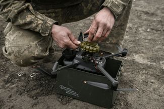 Военнослужащий ВСУ устанавливает на коммерческий дрон боеприпас — ручную гранату, район Бахмута. 15 марта 2023 года