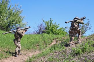 Украинские военные несут реактивные установки «Игла» на свои позиции под Бахмутом