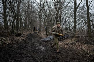 Украинский военнослужащий несет снаряд для гаубицы