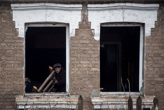 67-летняя жительница Краматорска Наталья в окне своего дома, поврежденного ракетным ударом. 17 декабря 2022 года