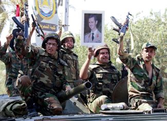 16 августа 2011 года. Сирийские солдаты с портретом президента Башара Асада в городе Дейр-аз-Зор, который они отбили у противников режима