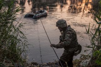 Украинский военный переправляется через реку неподалеку от Лисичанска. 19 июня 2022 года