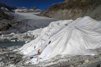 Ронский ледник в кантоне Вале в Швейцарии частично обернут термоизоляционным материалом для защиты от таяния. В течение 2021 года ледники Швейцарии потеряли 1% своего объема <a href="https://meduza.io/feature/2021/11/12/posmotrite-kak-globalnoe-poteplenie-uzhe-seychas-menyaet-nash-mir" rel="noopener noreferrer" target="_blank">из-за глобального потепления</a>. 27 октября