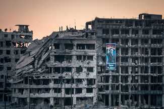 Плакат в поддержку Асада на разрушенном торговом центре в Хомсе, Сирия, 15 июня 2014-го
