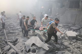 Палестинцы эвакуируют раненых после авиаудара по Рафаху на границе с Египтом. 12 октября 2023 года