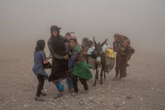 Жительницы провинции Герат на западе Афганистана несут полученную гуманитарную помощь. Они напуганы песчаной бурей, которая началась вскоре после землетрясения 7 октября. По оценкам Всемирной организации здравоохранения, в результате землетрясения погибли 1482 человека