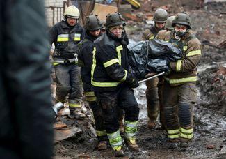 Спасатели выносят из-под завалов тело 55-летней Ирины Осадчей, директора Краеведческого музея, погибшей во время обстрела