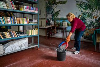 Работница библиотеки занимается уборкой помещения после ракетного обстрела. Харьков находится под постоянными ударами с 24 февраля, однако взять город российским войскам не удалось