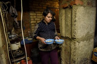 Жительница Лимана с едой, которую она приготовила в подвале многоквартирного дома