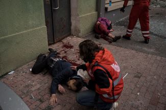 Спасатели пытаются помочь раненым во время бомбардировки Харькова