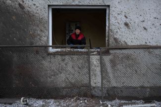 Киевлянин в окне своего дома после российского обстрела