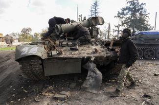 Украинские военные готовятся к буксировке захваченного российского танка возле недавно отвоеванного Купянска в Харьковской области
