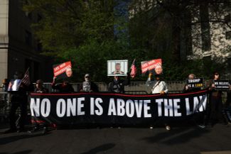 Активисты правозащитного движения Rise and Resist («Восстань и сопротивляйся»), сформировавшегося в 2016 году из людей, недовольных избранием Дональда Трампа на пост президента США, проводят у здания Федерального окружного суда в Нью-Йорке акцию в поддержку Джин Кэрролл. «Никто не может быть выше закона» — надпись на транспаранте демонстрантов