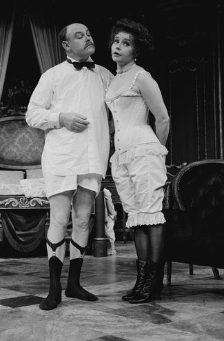 Английский актер Тимоти Уэст в носках с подтяжками вместе со своей женой, актрисой Прунеллой Скейлс. Сцена из спектакля «Big In Brazil», 1984 год