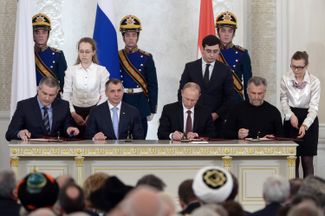 Vladimir Putin signs the treaty on Crimea’s admission into Russia. March 18, 2014.