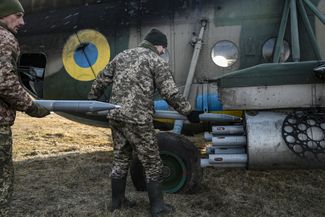 Украинские военные загружают ракеты в вертолет Ми-8