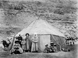 A Kyrgyz family stands outside of a yurt, 1907