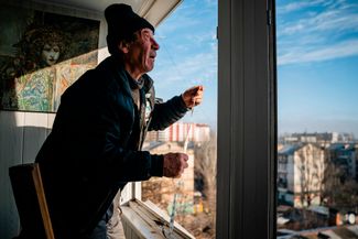 Житель Херсона измеряет в своей квартире окно, разбитое во время обстрела