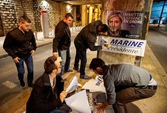 Сторонники Марин Ле Пен расклеивают плакаты