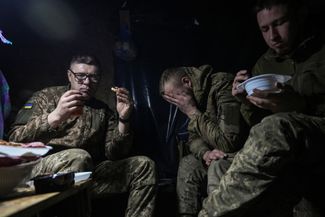 Украинские военные обедают в землянке на передовой