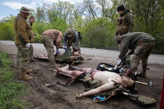 Военные медики оказывают помощь раненым бойцам ВСУ на дороге возле Бахмута
