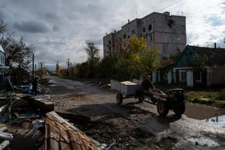 Житель поселка на фоне разрушенного склада