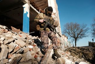 Украинский военный на месте одного из разрушенных зданий в Купянске после испытаний дрона