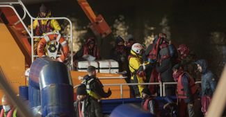 Мигранты, спасенные британскими пограничниками с затонувшего 25 ноября судна, высаживаются в порту Дувра