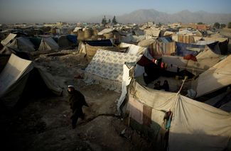 Афганец Аман Уллех идет по лагерю беженцев в Кабуле. 28 июня 2008 года