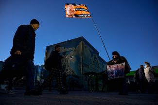Прокремлевский активист проводит одиночный пикет с флагом и плакатом с портретом президента в Москве. Надпись на плакате гласит: «Мы с ним. За суверенитет России. А ты?!» 17 марта 2023 года
