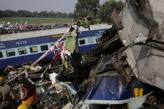 Спасатели на месте крушения пассажирского поезда на севере Индии. 20 ноября 2016 года
