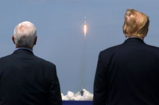 Президент США Дональд Трамп вместе с вице-президентом Майком Пенсом наблюдают за стартом ракеты Falcon 9 компании SpaceX, которая доставит к МКС космический корабль Crew Dragon с астронавтами на борту — впервые в истории. Флорида, 30 мая 2020 года