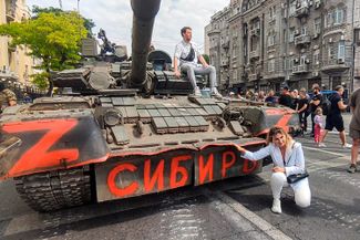 A resident of Rostov-on-Don poses in front of a tank.
