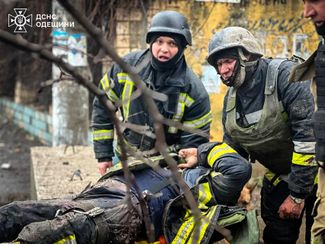 Спасатели помогают своему товарищу, раненому во время российской атаки