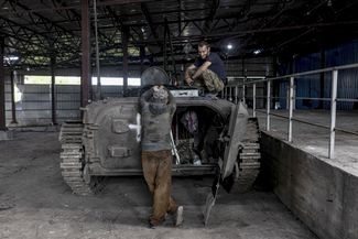 Украинские солдаты работают над ремонтом боевой машины пехоты (БМП) в гараже в Донецкой области