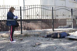 Врач осматривает тело погибшего жителя Донецка после обстрела Куйбышевского района
