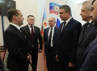 Medvedev (left) speaks to other participants in Thursday’s meeting in Luhansk.