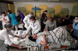 Медики переносят пациентов в бомбоубежище в подвале мариупольского роддома. 1 марта 2022 года