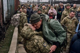 Украинская военнослужащая целует члена своей семьи при встрече на вокзале Краматорска. 29 марта 2023 года 