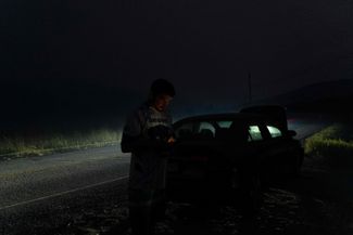 Дэвид Купер, житель провинции Британская Колумбия, стоит на обочине шоссе. Его машина сломалась во время эвакуации