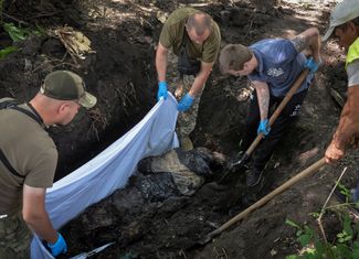 Волонтеры и служащие ВСУ эксгумируют тело российского солдата, который был похоронен в Харькове несколько месяцев назад.