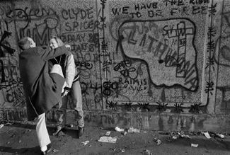 Жители Западного Берлина забираются на стену. 10 ноября 1989 года