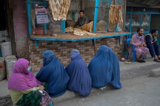 Женщины в бурках ждут бесплатного хлеба напротив пекарни в Кабуле, 16 сентября 2021.