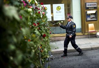 Сотрудник полиции на акции против насилия в центре Осло, 25 июля 2011 года