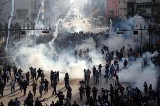 28 января 2011 года. Протестующие в облаке слезоточивого газа в Каире. Хосни Мубарак правил Египтом с 1981 года, его режим считался одним из самых стабильных в регионе