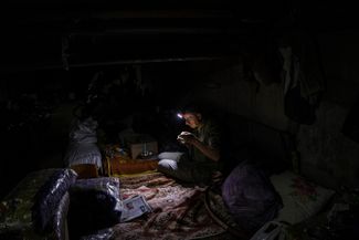 Украинский мирный житель ужинает в подвале, который служит в качестве бомбоубежища