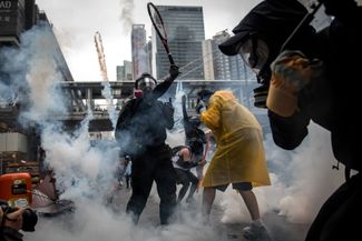 A protester in Hong Kong uses a tennis racket to deflect tear-gas grenades fired by the police on August 25, 2019.