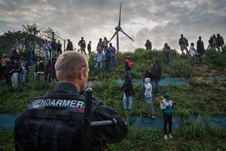 Сотрудники французской жандармерии пытаются помешать мигрантам пробраться в Евротоннель