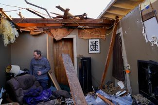 70-летний житель Мэйфилда Рик Фоули стоит в своей разрушенной гостиной