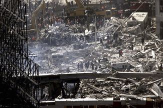 Спасатели и пожарные ищут людей под развалинами небоскребов. В результате терактов 11 сентября погибли более 400 работников спасательных служб